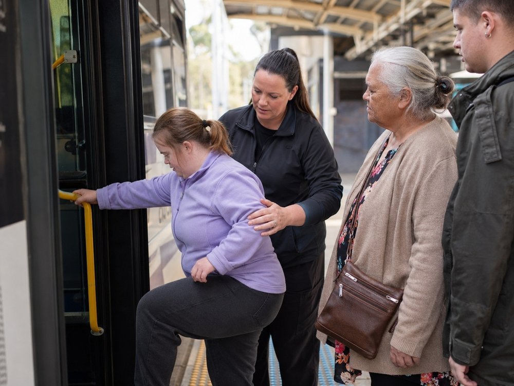 A support worker helping a participant board public transport at a local station